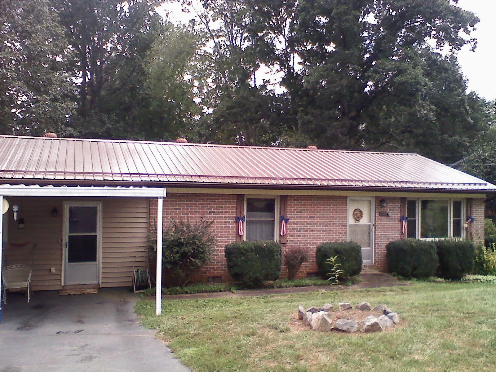 Bronze metal roof and carport on a brick ranch home — Roof Repair work by our crew in Star Junction